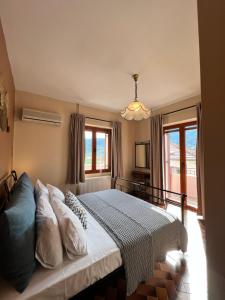 瓦西Antonios House Ithaka的一间卧室配有带白色床单和枕头的床。