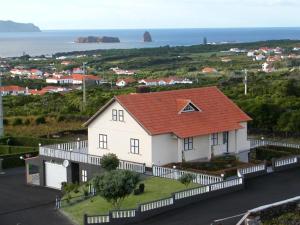 马达莱纳Moradia Familiar NovaVista - T3的一座白色的房子,有橙色的屋顶和大海