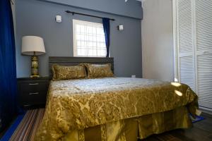 昂斯拉雷区La Vue的一间卧室配有一张带黄色床罩的床和窗户