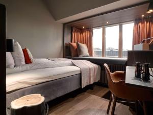 斯德哥尔摩斯堪迪克坎佩尔市区酒店的一间卧室设有一张大床和一个窗户。