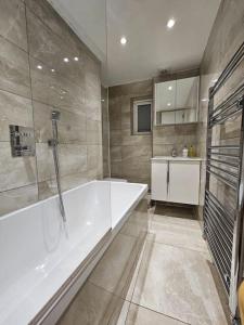 伦敦cosy apartment Alexandra palace Haringey, London的带浴缸和盥洗盆的大浴室