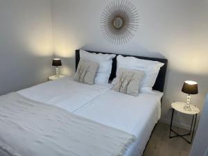 博伦多夫Gemütliche&Moderne Ferienwohnung Nähe Trier & Luxemburg的一张带两个枕头和镜子的白色床