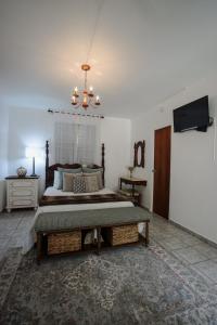 卡沃罗霍Hacienda Tres Casitas的一间卧室配有一张带吊灯的大床