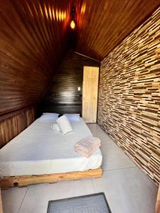 图里亚尔瓦Casa Tucan Glamping的卧室配有木墙内的一张床