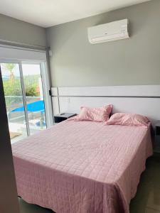 阿蒂巴亚Apartamento próximo da Lucas的一间卧室配有粉红色的床和粉色毯子