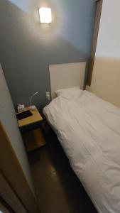 Sanuki宿 inn TEK-TEK的卧室配有白色的床和床头柜