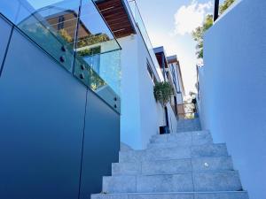 悉尼Manly Paradise Apartment的一座带玻璃墙和混凝土楼梯的房子