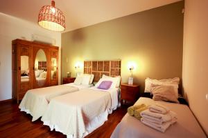 圣拉斐尔Posada La Victoria的一间带三张床的卧室,配有白色床单