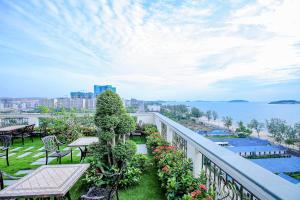 西哈努克Sea Breeze Hotel & Villa的阳台配有桌椅,享有水景。