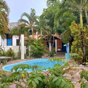 萨尔瓦多Pousada Mares de Stella的棕榈树屋前的游泳池