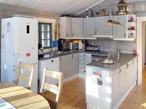 DrangedalHoliday home Drangedal II的厨房配有白色橱柜和白色冰箱。