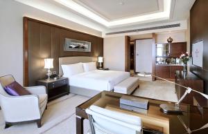 天津天津京基皇冠假日酒店的配有一张床和一张书桌的酒店客房
