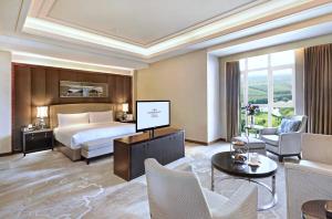 天津天津京基皇冠假日酒店的一间酒店客房,配有一张床和一台电视