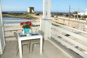 托雷拉皮罗Altomare Case Vacanza的海景阳台上的鲜花桌