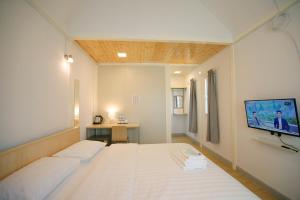 佛统Barn Sampran Resort บ้านสามพรานรีสอร์ท的一间医院间 - 带床和平面电视