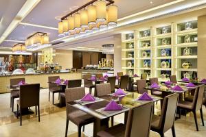 天津天津京基皇冠假日酒店的餐厅配有桌椅和紫色餐巾
