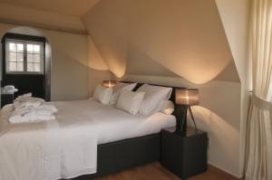 克诺克－海斯特B&B Colombe Blanche的一间卧室配有一张带白色床单的床和一扇窗户。