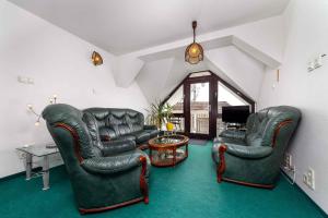 巴拉顿博格拉尔House and Apt in Balatonboglar 42692的客厅配有两张真皮座椅和一张桌子