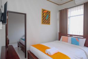 日惹Sans Hotel Kumbang Yogyakarta by RedDoorz的一间卧室配有一张带镜子的床和窗户