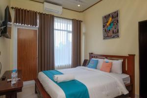 日惹Sans Hotel Kumbang Yogyakarta by RedDoorz的一间卧室设有一张大床和一个窗户。