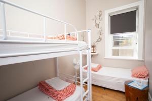 埃利奥特港YHA Port Elliot Beach House的小型客房设有两张双层床和窗户。