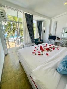 迪克韦勒Smeralda Beach Hotel Dikwella的一间卧室,床上有红色玫瑰