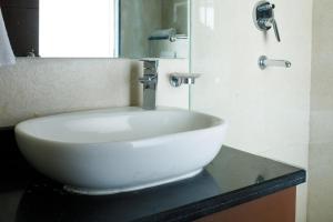 加德满都Sangam City Hotel Pure Veg的浴室内一个柜台上的白色水槽
