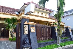 日惹茹玛康婷家庭旅馆的一座房子,前面有门和雕像