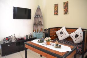 日惹茹玛康婷家庭旅馆的客厅配有咖啡桌和电视