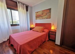 尼格兰P° Olmos, Panxón, bajo con jardín privado的一间卧室配有红色的床和2个床头柜