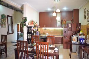 日惹茹玛康婷家庭旅馆的厨房配有桌椅和冰箱。
