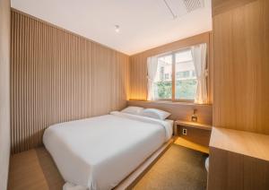 庆州UH Suite Gyeongju的一间小卧室,配有白色的床和窗户