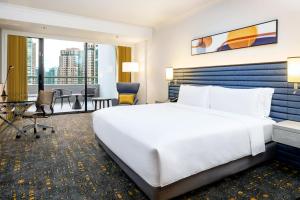 新加坡voco Orchard Singapore, an IHG Hotel的酒店客房设有一张大床和一张书桌。