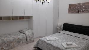 内比达Casa vacanza Maligio' Nebida Masua的一间卧室配有一张床、一张沙发和一个吊灯。