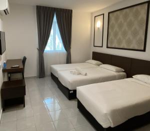 Kampong MortenCapital O 90756 Cara Hulu Hotel的酒店客房设有两张床和窗户。