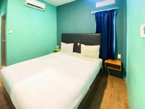 棉兰Sentosa Jaya Guest House near RS Hermina Medan RedPartner的一间卧室配有一张白色大床和蓝色的墙壁