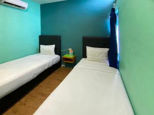 棉兰Sentosa Jaya Guest House near RS Hermina Medan RedPartner的蓝色墙壁客房的两张床