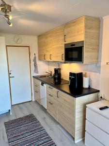 雪平斯维克Holiday Apartment Köpingsvik的厨房配有木制橱柜和黑色台面