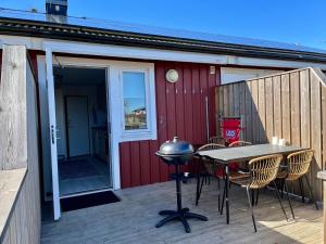 雪平斯维克Holiday Apartment Köpingsvik的一个带桌椅和烧烤架的庭院