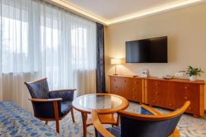 赫维兹哈维兹宫殿酒店的酒店客房配有桌椅和电视。
