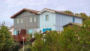 勒泰克玛达姆瓦康斯 - 列维玛琳酒店的带阳台和树木的大型蓝色房屋