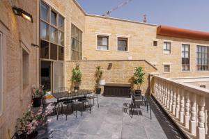 耶路撒冷Grand Jerusalem Luxury Apartment By Nimizz的大楼前带桌椅的天井
