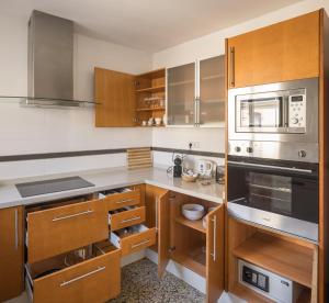 瓦伦西亚Macflats Valencia Puerto的厨房配有不锈钢用具和木柜