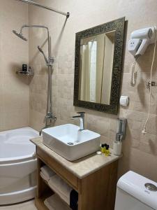 布哈拉As-Salam Boutique Hotel的一间带水槽、卫生间和镜子的浴室