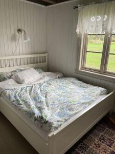 HemnesVeslestua - Beach Bliss & Fishing Fun的卧室内的一张床铺,带窗户