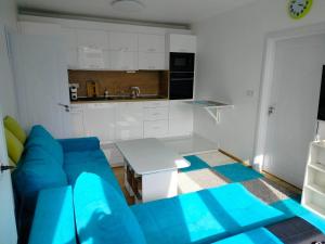 索非亚Alinik Apartment的一间带蓝色沙发的客厅和一间厨房