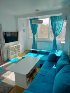 索非亚Alinik Apartment的客厅配有蓝色的沙发和桌子