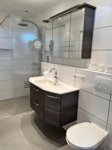 诺德奈Haus Janus 3 - Wohnung 1的一间带水槽、卫生间和镜子的浴室