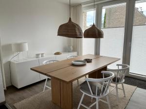诺德奈Haus Janus 3 - Wohnung 1的一间带木桌和椅子的用餐室