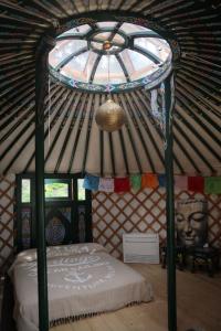 蒙赞巴诺Agriturismo Olistico Atman的蒙古包内带床的房间,带窗户